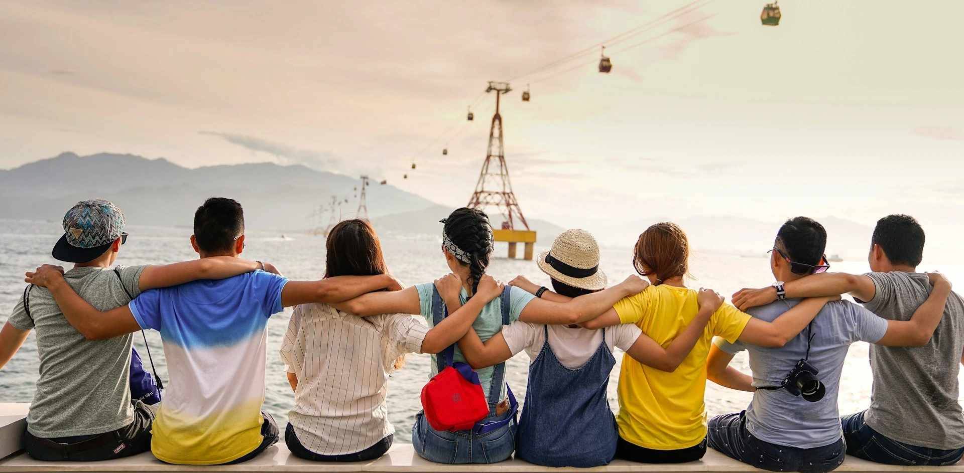 people holding shoulders sitting on wall
